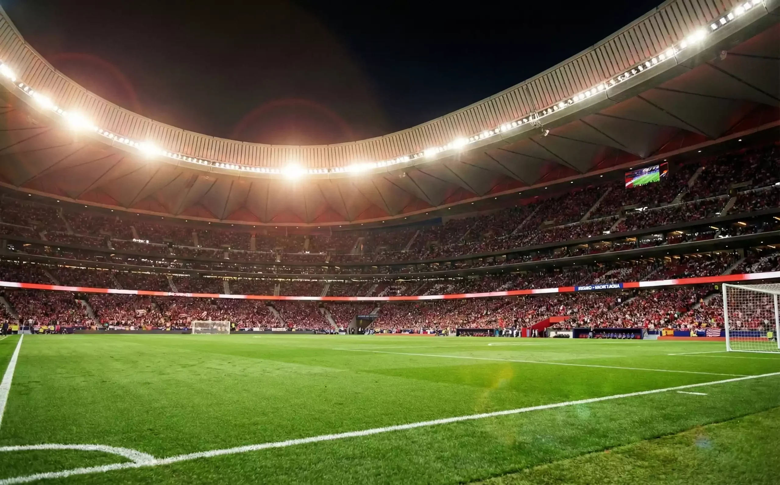 Estadio de fútbol español iluminado durante un partido nocturno con aficionados en las gradas